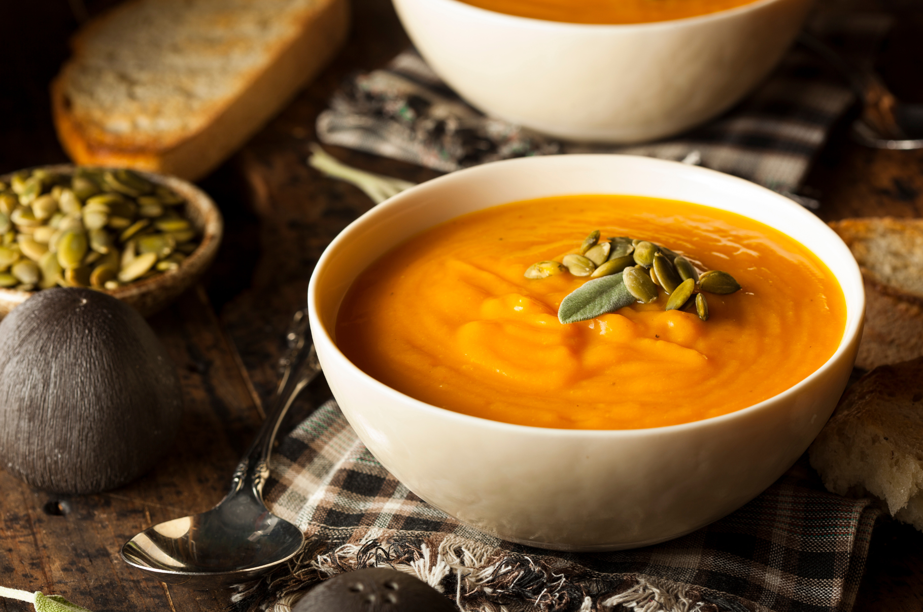 Image of Warm bowl of creamy butternut squash soup topped with pumpkin seeds and sage — a rich autumn dish that embodies the seasonal flavor and presentation style of Pro Chefly’s kitchen.